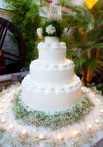 Beautiful white wedding cake with small candels.