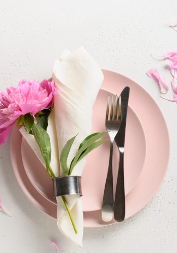 Elegance romantic table setting with pink peony flowers on a white table. View from above.