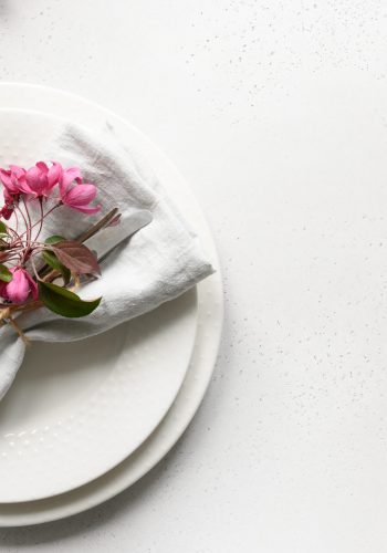 Elegance romantic table setting with apple tree flowers on white table. Top view. Space for text.